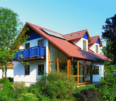 Casa prefabricada con balcones azules y jardín